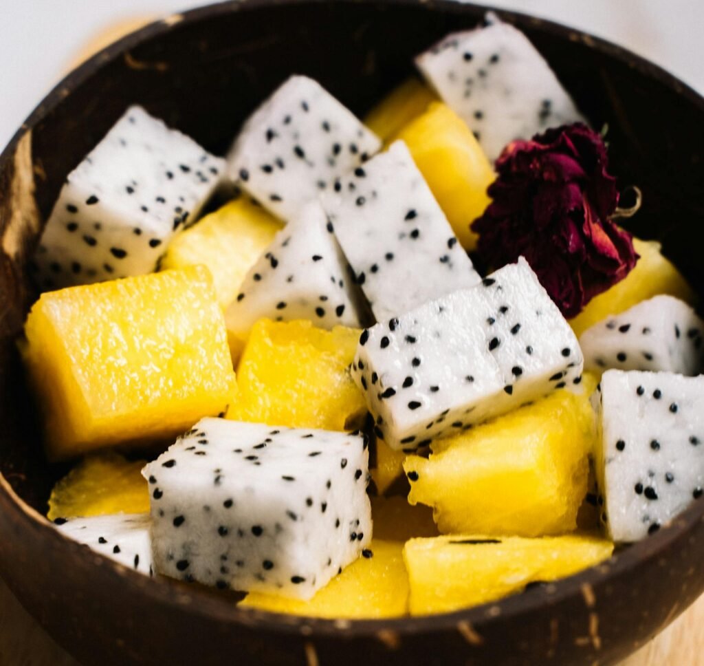 Close-up of a fresh tropical fruit bowl featuring dragon fruit and pineapple cubes.