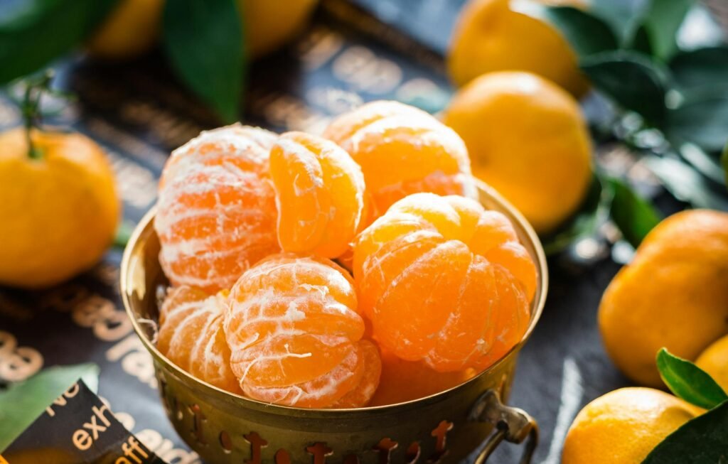 Vibrant peeled and whole tangerines in a rustic bowl highlighting freshness and health.