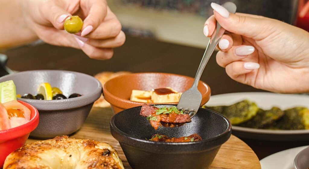 A delightful Middle Eastern breakfast spread featuring olives, bread, and various small dishes, showcasing vibrant flavors.